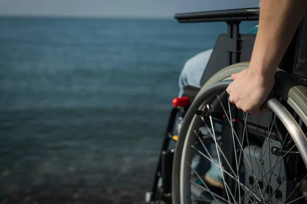 Deniz kıyısında tekerlekli sandalyedeki beyaz kadın. Kadın ellerine yakın çekim. — Stok fotoğraf