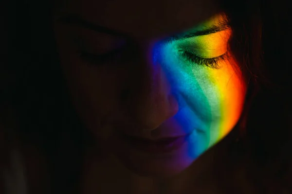 Close-up portrait of caucasian woman with ray of rainbow light on her face. — Fotografia de Stock