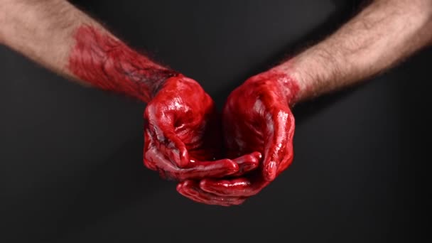 Blood pouring over male hands on a black background. — Stock Video