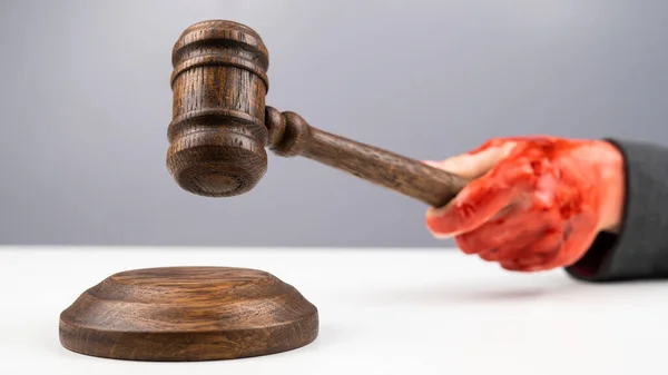 Female judge with bloody hands beats the gavel on a white background. — Stock Photo, Image