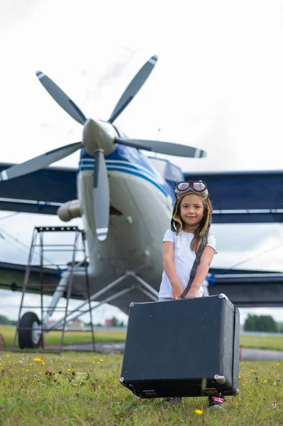 Una linda niña jugando en el campo por jet privado soñando con convertirse en piloto —  Fotos de Stock