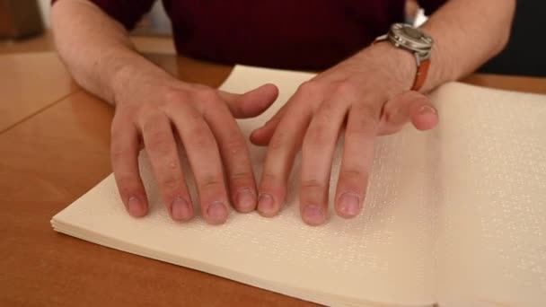 Sehbehinderter Mann liest ein Braillebuch. — Stockvideo