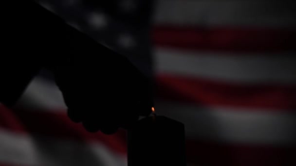 Καίγοντας κερί στο φόντο του κυματίζει σημαία των Ηνωμένων Πολιτειών της Αμερικής στο σκοτάδι. — Αρχείο Βίντεο