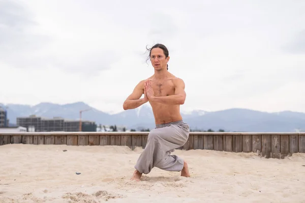 Uomo caucasico con i capelli lunghi che praticano il qigong all'aperto. — Foto Stock