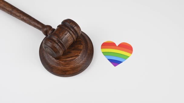 Juiz bate um martelo ao lado de um coração com um arco-íris. — Vídeo de Stock