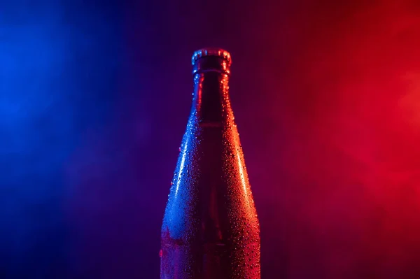 Skleněná láhev piva v modré růžové mlze — Stock fotografie