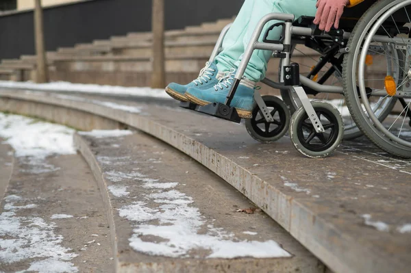 Mujer en silla de ruedas cerca de las escaleras en el parque en invierno. — Foto de Stock