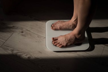 Elektronik ölçekte kadın bacaklarının yakın çekimi. 