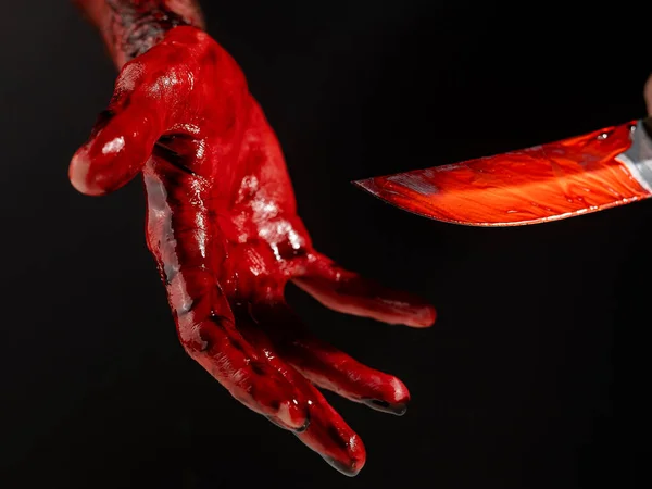 Cuchillo hombre con mano ensangrentada sobre fondo negro. — Foto de Stock