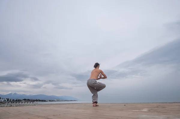 海岸で武術を練習している裸の胴を持つ白人男性. — ストック写真