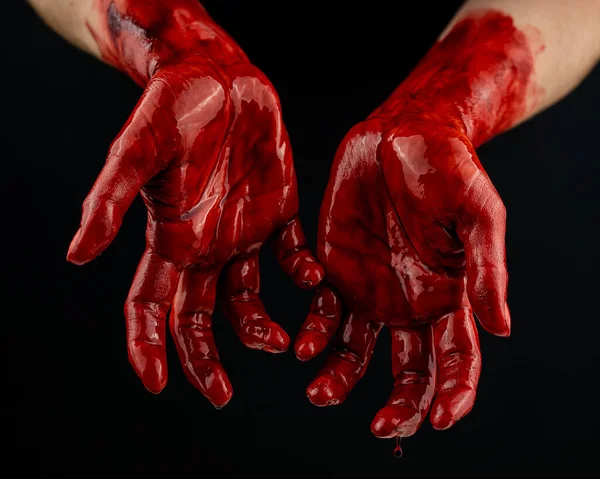 Las manos de las mujeres en la sangre sobre un fondo negro. — Foto de Stock