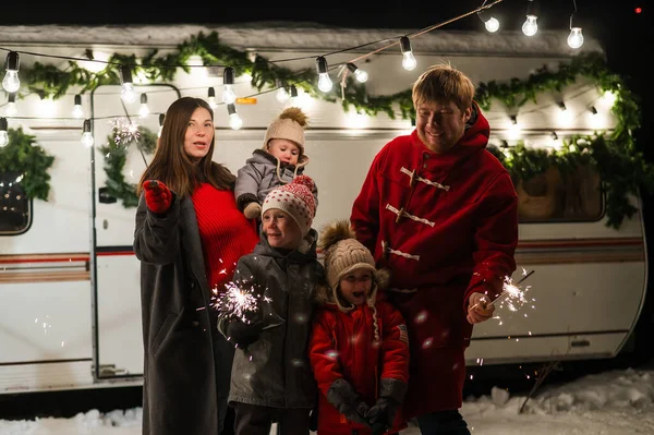 Happy parents with three sons celebrating christmas in motorhome.