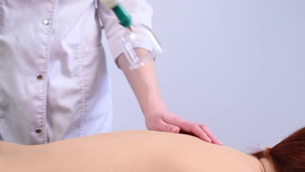 Női masszázs terapeuta használ vákuum dobozok a betegek hátán. — Stock videók