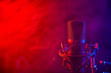 Siyah arka planda pembe dumanlı profesyonel mikrofon..