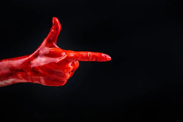 Mulheres mão no sangue mostra um gesto de uma arma em um fundo preto. — Fotografia de Stock