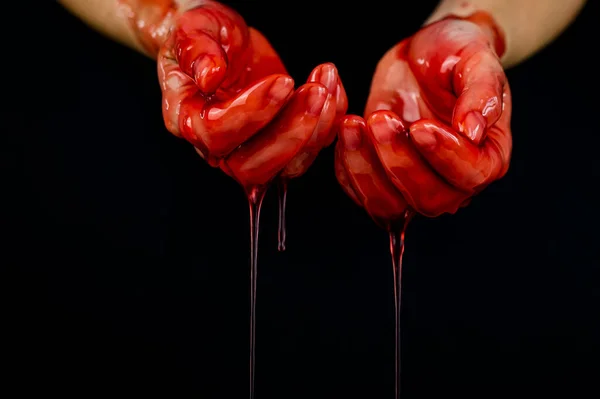 Les mains des femmes dans un liquide rouge visqueux similaire au sang. — Photo