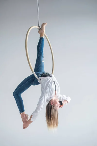 Femme gymnaste caucasienne faire des exercices de cerceau aérien et en utilisant un smartphone. — Photo