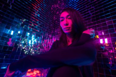 Asyalı adam güneş gözlüğü tutuyor. Neon fotoğraf stüdyosu. 