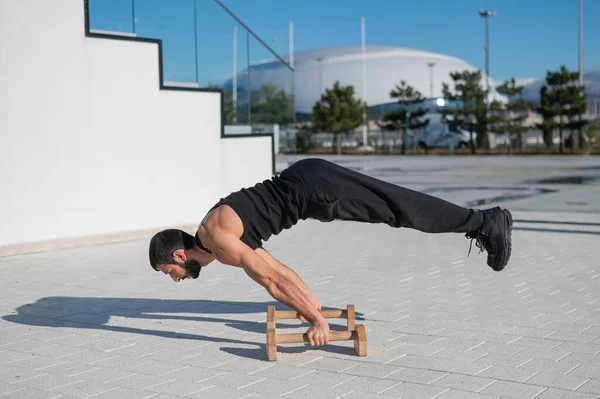 Hombre haciendo ejercicio de equilibrio en barras de piso para la aptitud. — Foto de Stock