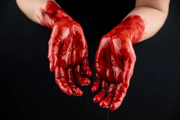 Frauenhände in Blut auf schwarzem Hintergrund. — Stockfoto