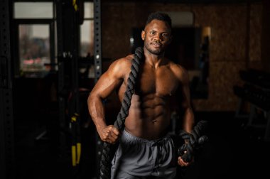 Kaslı Afrikalı Amerikalı adam spor salonunda iple poz veriyor.. 