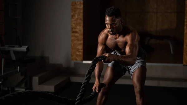 Atraktivní africký Američan s nahým trupem dělá vytrvalostní cvičení s trofejí. — Stock fotografie