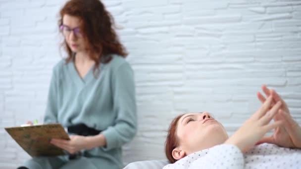 Orta yaşlı bir kadın kanepeye uzanıp bir psikologla konuşuyor.. — Stok video