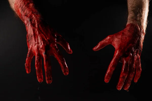 Мужские окровавленные руки на черном фоне. — стоковое фото