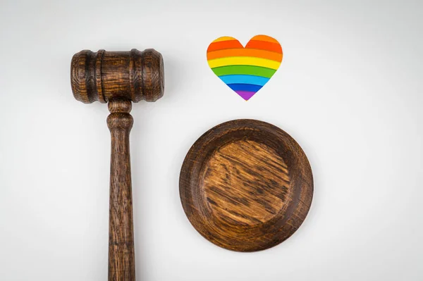 Martillo judicial y corazón con bandera de arco iris sobre fondo blanco. Proteger los derechos de los homosexuales en los tribunales. —  Fotos de Stock
