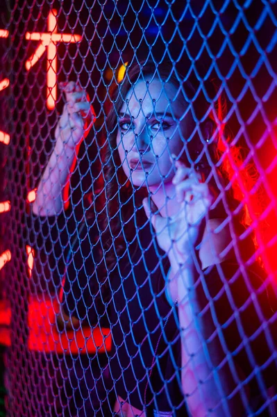 Neon Stüdyosunda beyaz kadın zincir örgüsünün arkasında.. — Stok fotoğraf