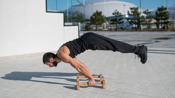 Férfi csinál egyensúly gyakorlat padlón bárok fitness. — Stock Fotó