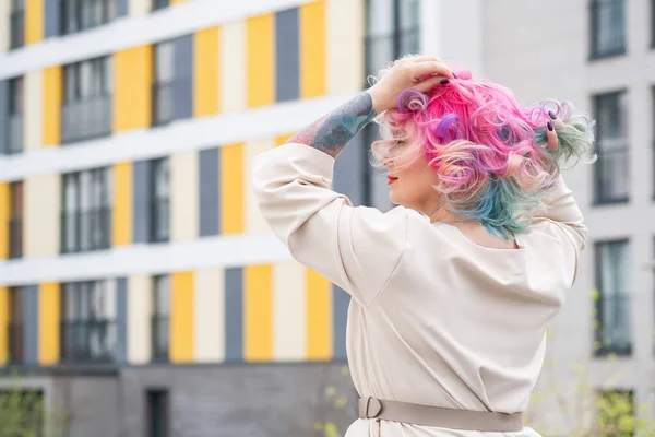 Retrato de una mujer de mediana edad con cabello multicolor pasea por las calles de la ciudad. —  Fotos de Stock