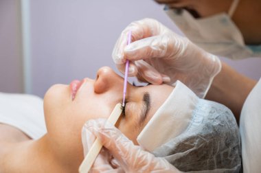 Kadınları tarama ustası kirpikleri kaplama öncesi hazırlıyor. 