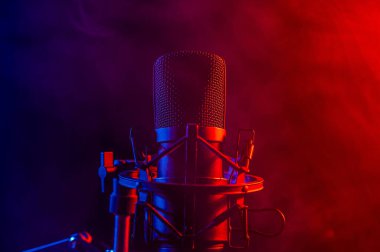 Siyah arka planda pembe dumanlı profesyonel mikrofon..