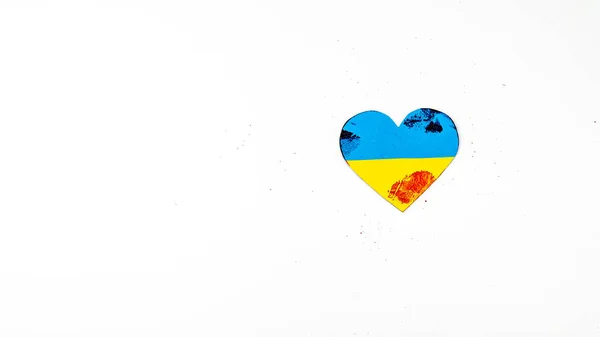 Coeur avec le drapeau de l'Ukraine est enduit de sang sur un fond blanc. — Photo