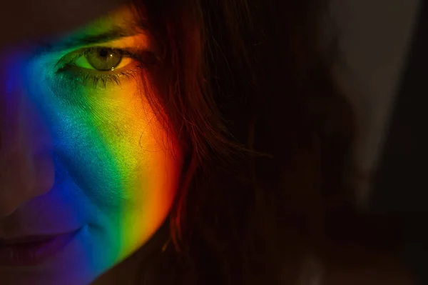 Close-up portrait of caucasian woman with ray of rainbow light on her face. — Fotografia de Stock