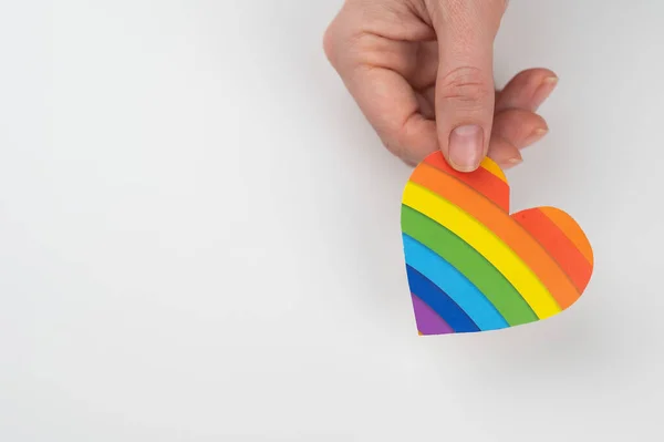 Manos femeninas con corazón de papel iris aisladas sobre fondo blanco. Copiar espacio. —  Fotos de Stock