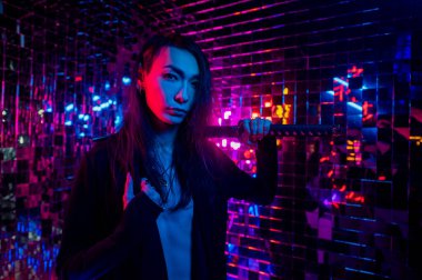 Erkek transseksüel neon ışık stüdyosu. Samuray kılıçlı Asyalı.