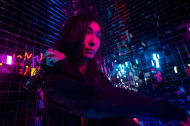 Asyalı adam güneş gözlüğü tutuyor. Neon fotoğraf stüdyosu. 