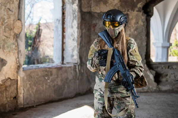 Portret kobiety w kasku i gogle z karabinem maszynowym w rękach. Żołnierka w kamuflażu trzyma broń.. — Zdjęcie stockowe