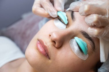 Sahip, müşteriye kirpikleri kaplamak için özel bir silindir takar.