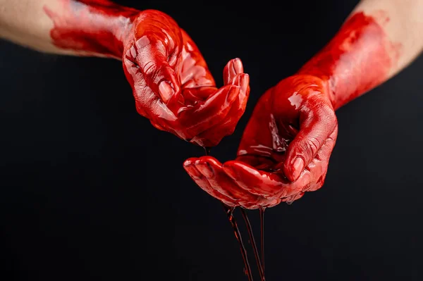 Mãos de mulher no sangue em um fundo preto. — Fotografia de Stock
