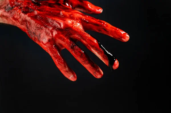 Primer plano de una mano masculina manchada de sangre sobre un fondo negro. — Foto de Stock