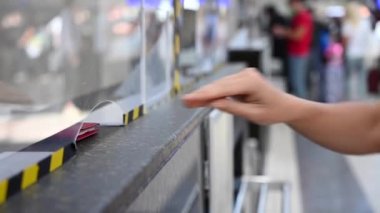 Kimliği belirsiz bir kadın pasaportunu ve biletini havaalanı gişesinden alıyor..