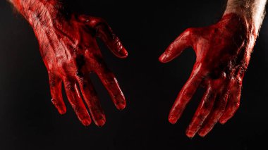Siyah arka planda kanlı erkek elleri. 