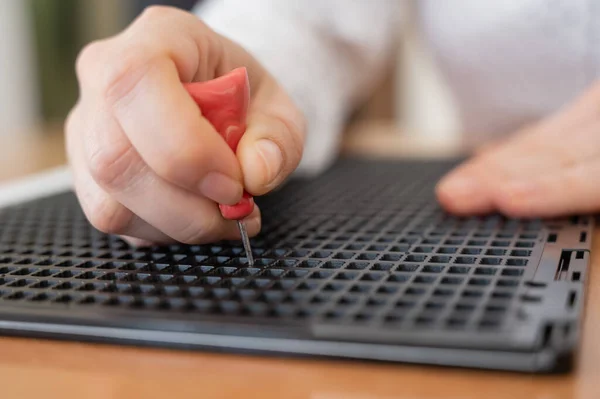 Una mujer usa una plantilla especial y un lápiz para escribir una carta en braille. — Foto de Stock