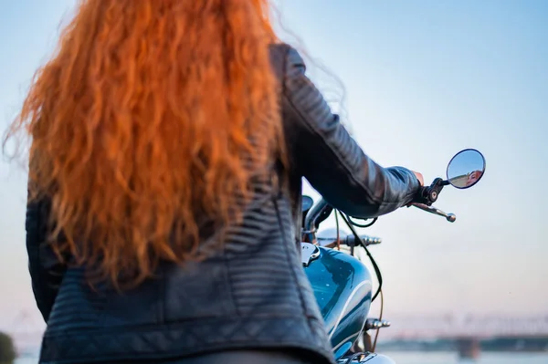 Deri motosikletli kızıl saçlı, kıvırcık kadının arka manzarası.. — Stok fotoğraf