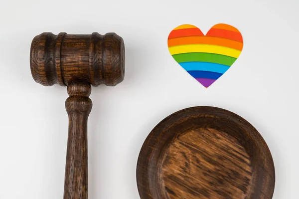 Martillo judicial y corazón con bandera de arco iris sobre fondo blanco. Proteger los derechos de los homosexuales en los tribunales. —  Fotos de Stock