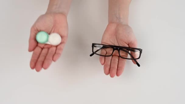 Une femme fait un choix entre des verres et des lunettes. Peser la décision et choisir des lunettes. — Video