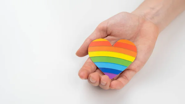 Female hands with rainbow paper heart isolated on white background. Copy space. — Stock Photo, Image